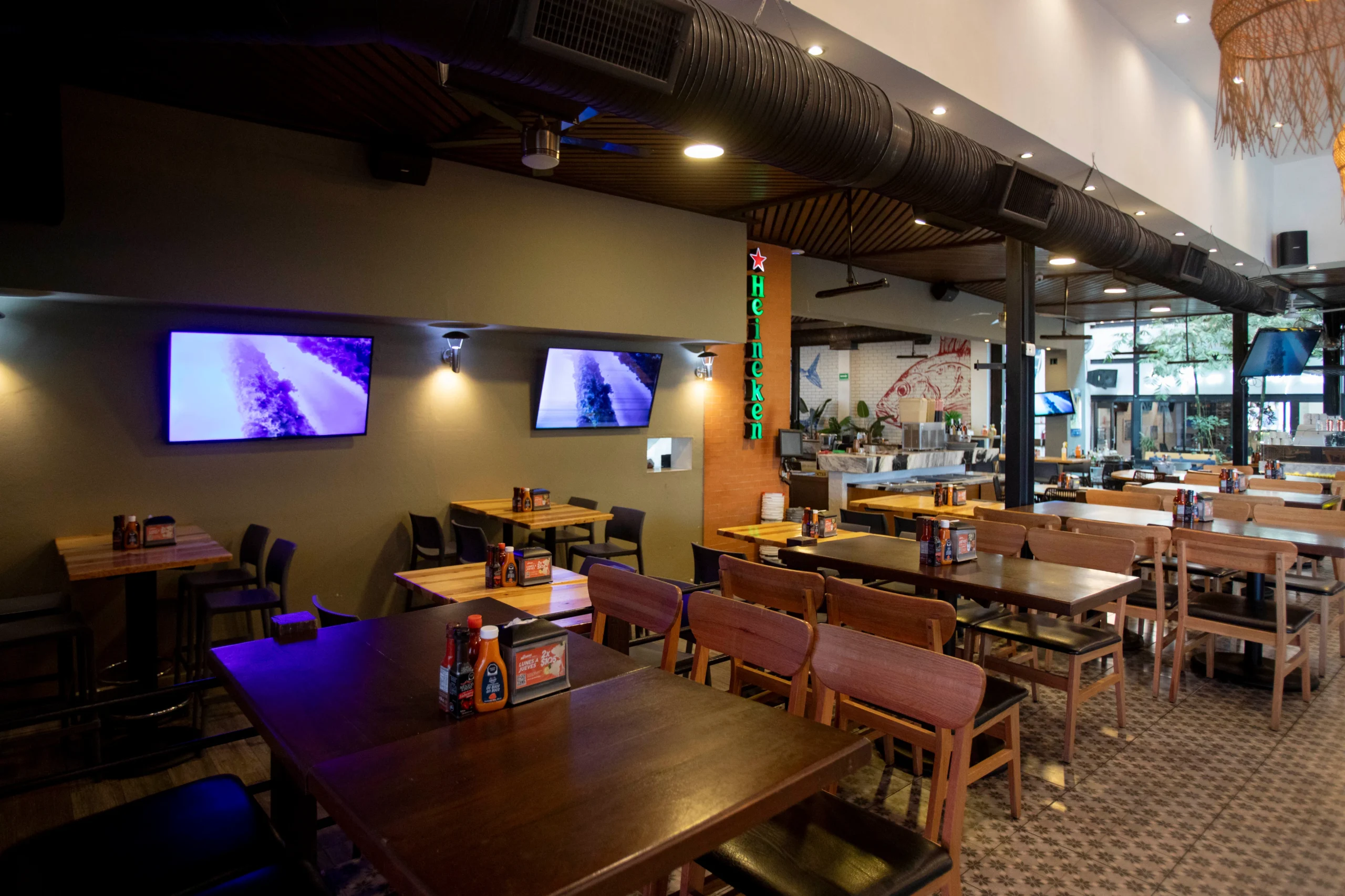 mesas y sillas en un restaurante con TV de pantalla plana