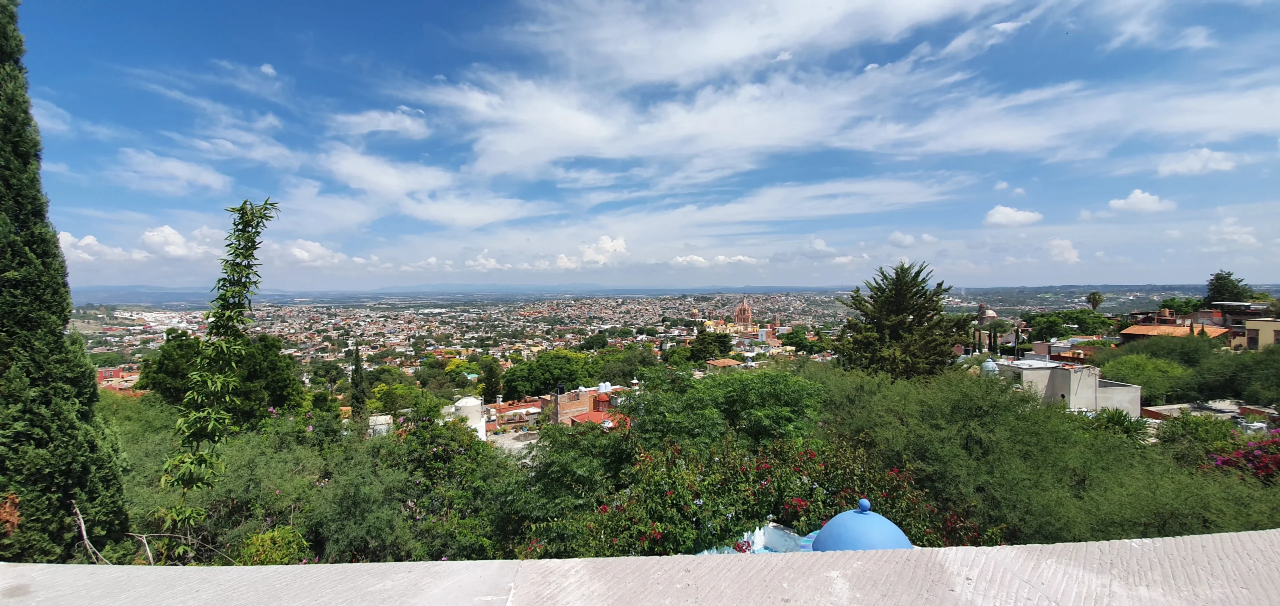 vista arafed de una ciudad desde una colina con una cúpula azul