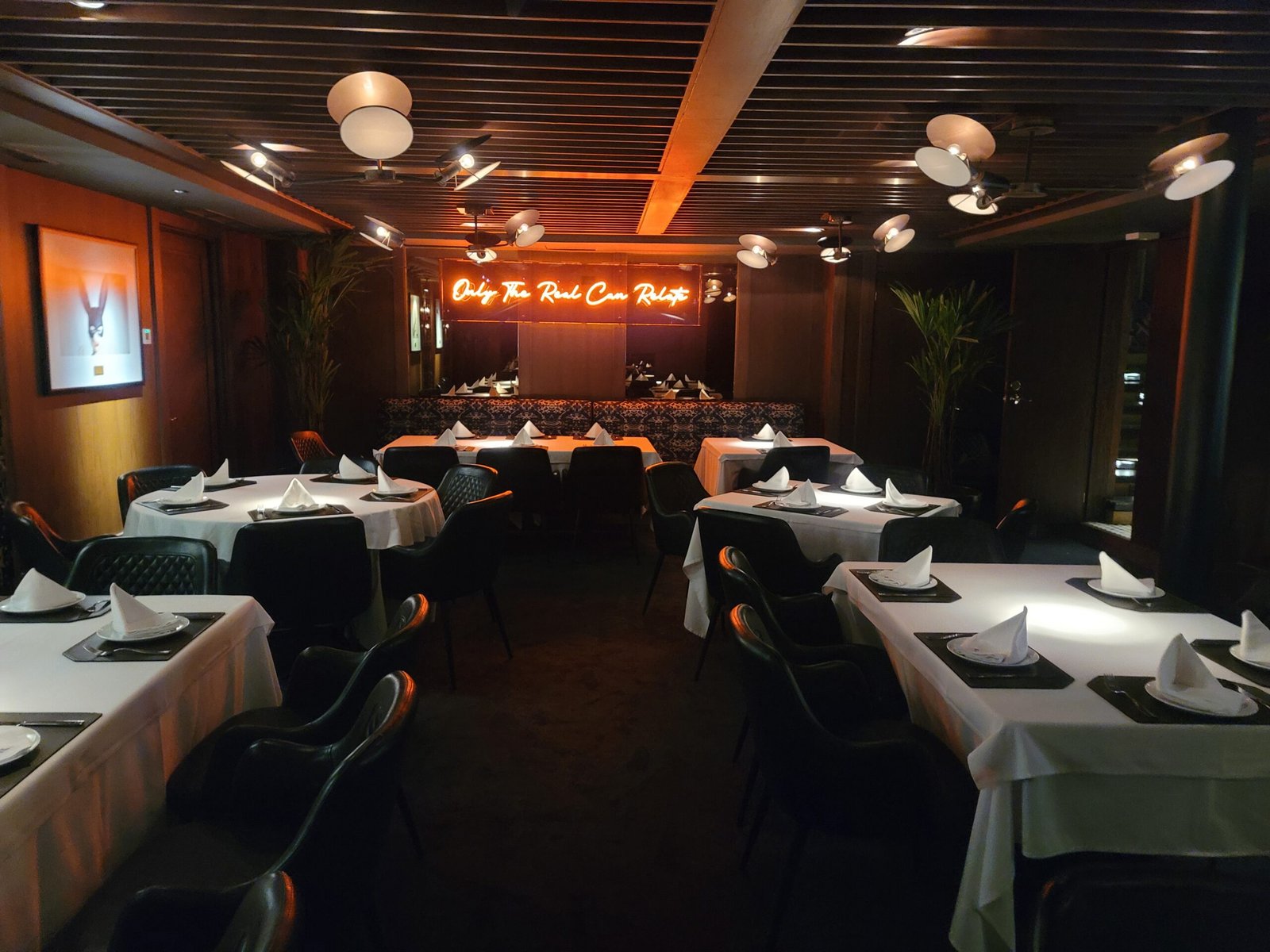 un restaurante con mesas y sillas y una gran pantalla