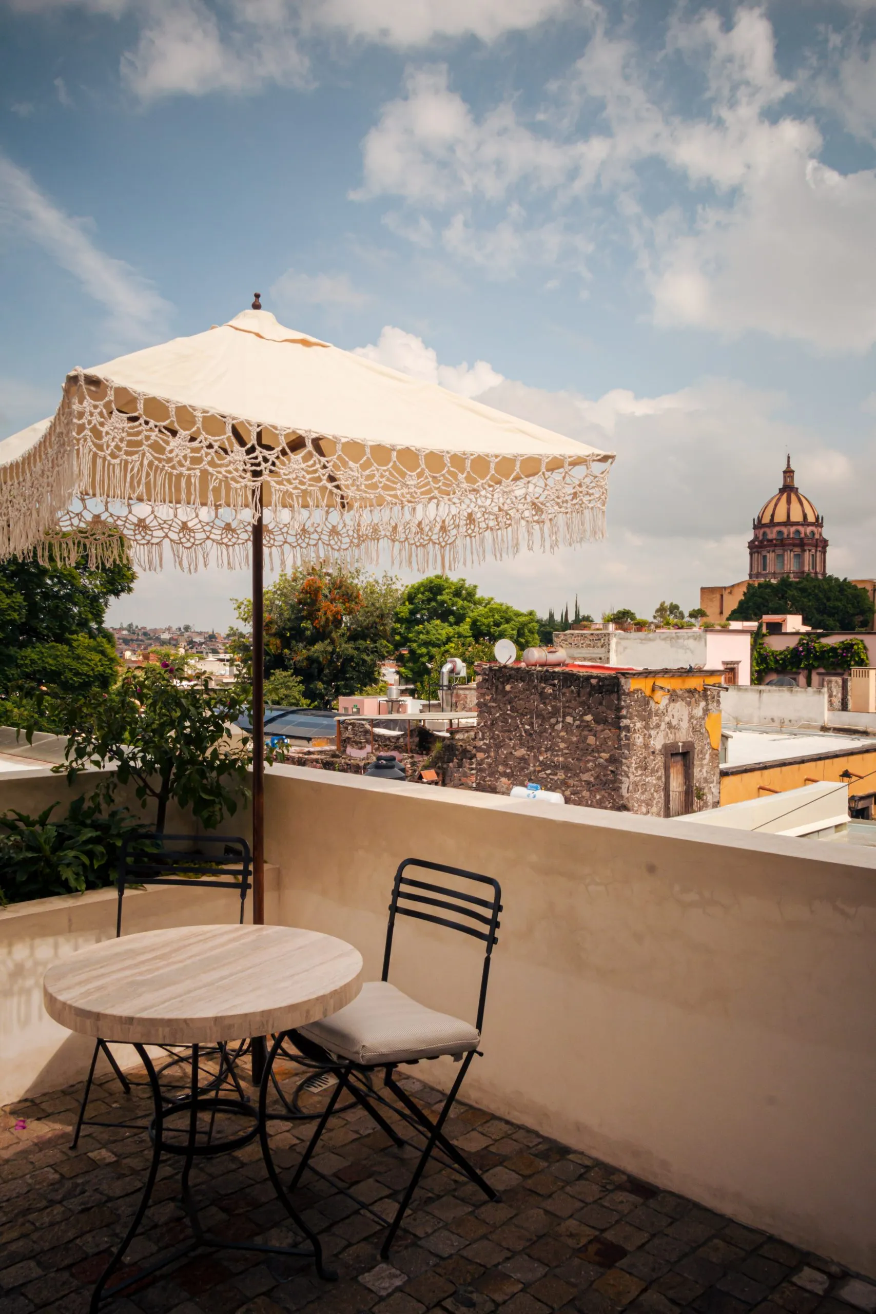 hay una mesa y sillas en un patio con un paraguas