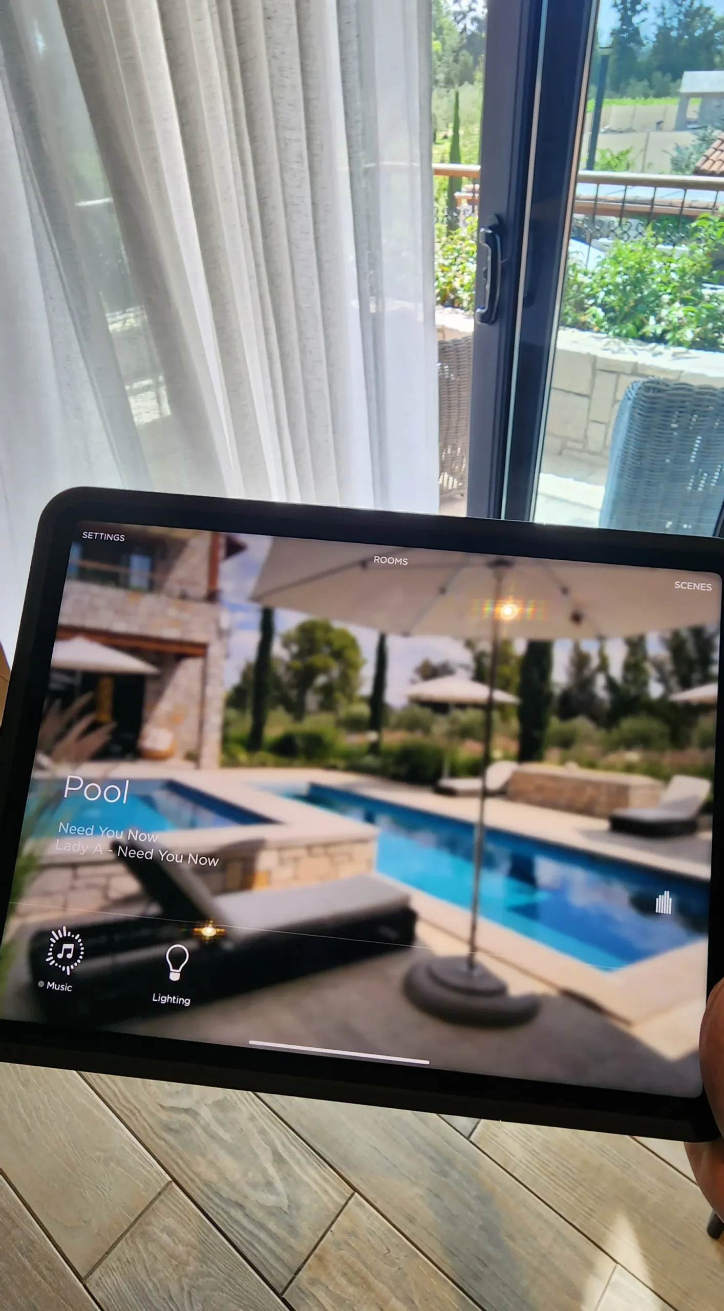 alguien sosteniendo una tableta con una foto de una piscina en ella