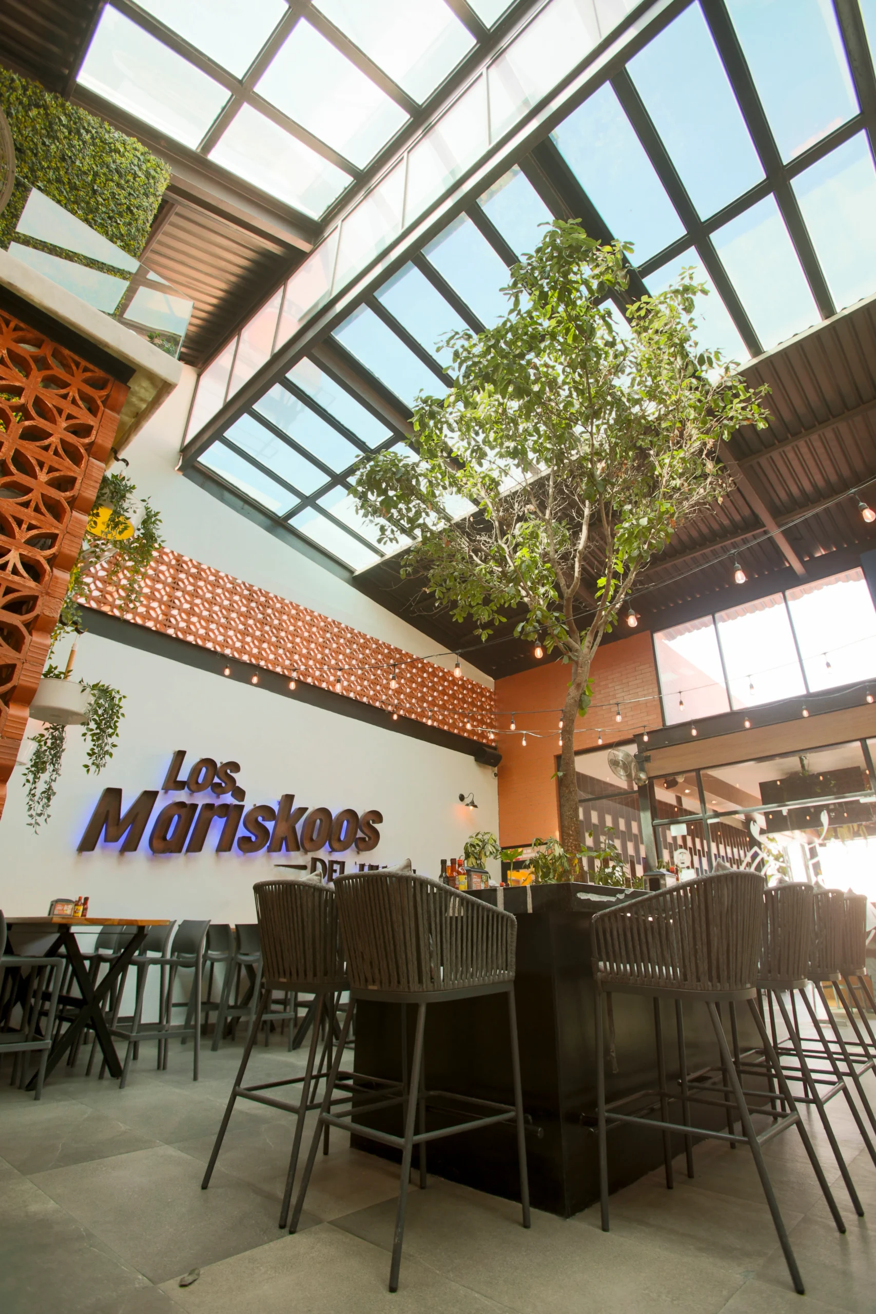 hay un árbol grande en medio de una habitación con sillas