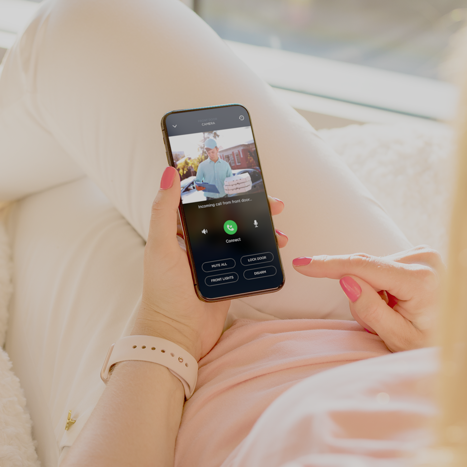 una mujer está sentada en un sofá y sosteniendo una celda