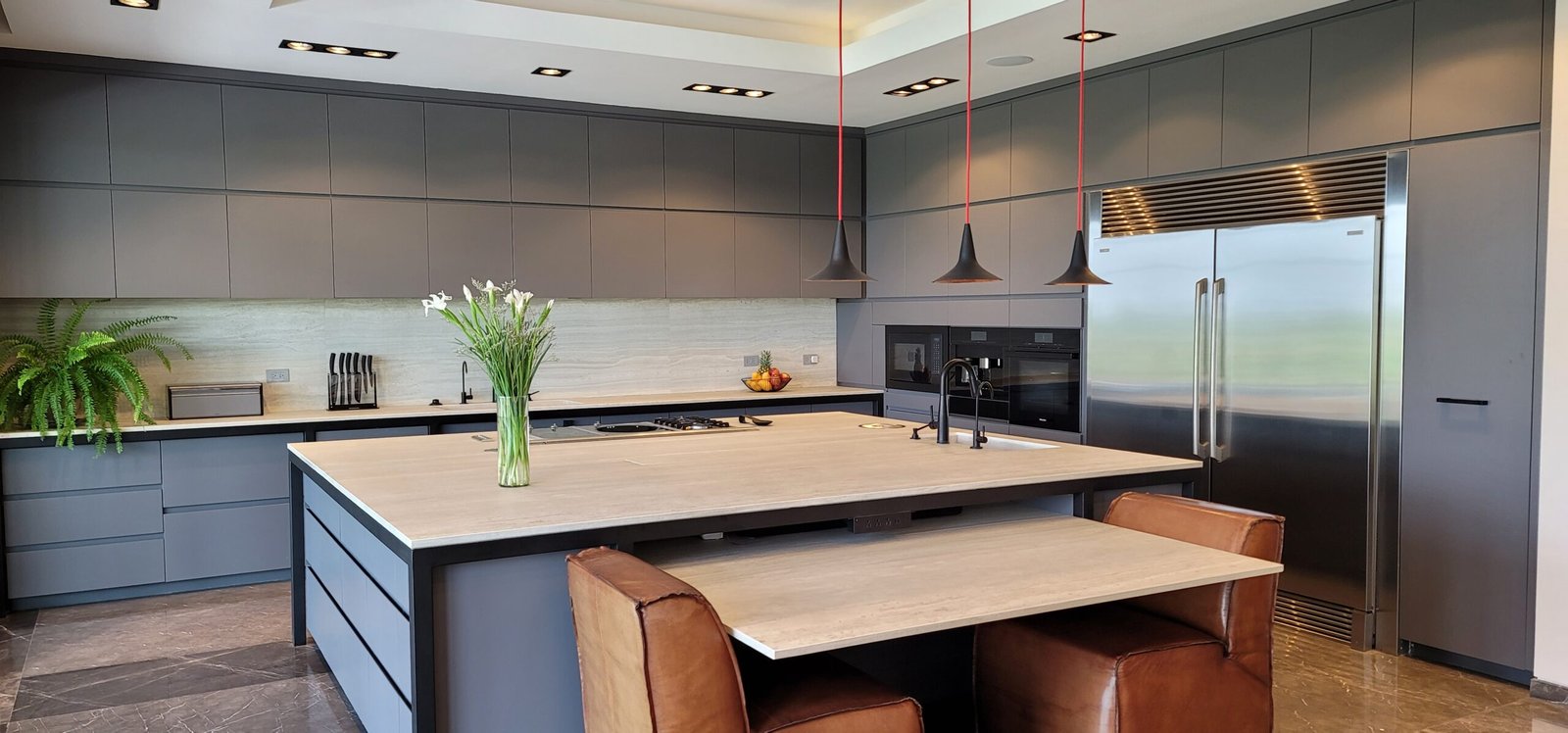 hay una cocina con una isla central y una mesa con sillas