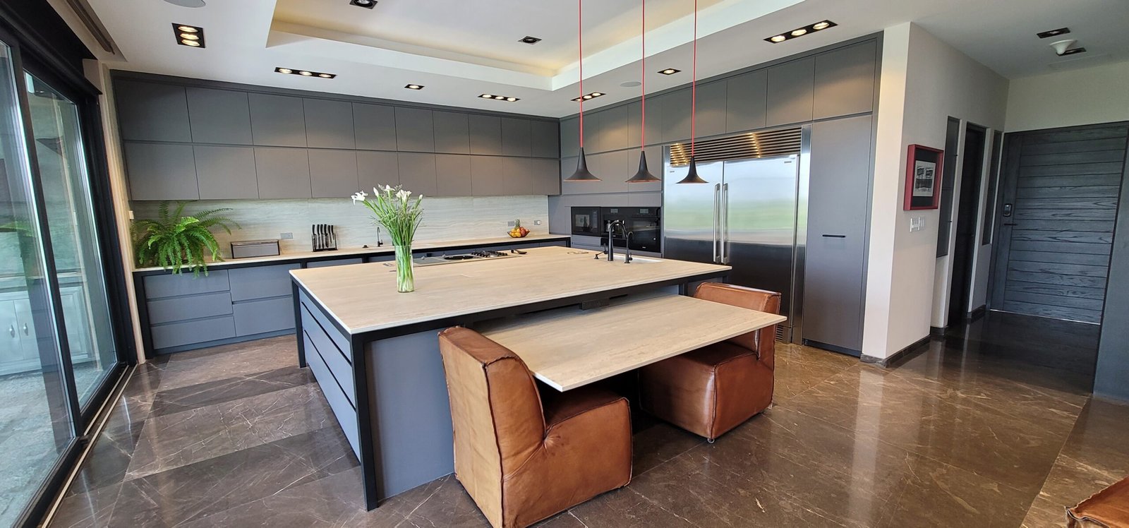 hay una cocina con una isla central y una mesa con sillas