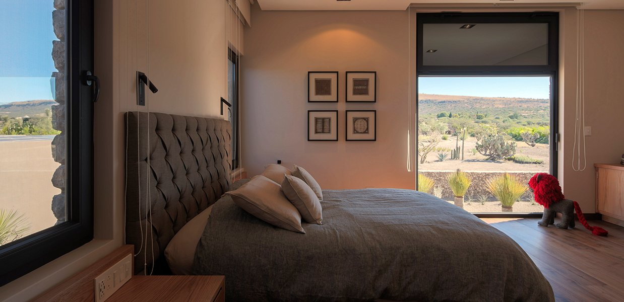 hay una cama con un edredón gris y almohadas en un dormitorio